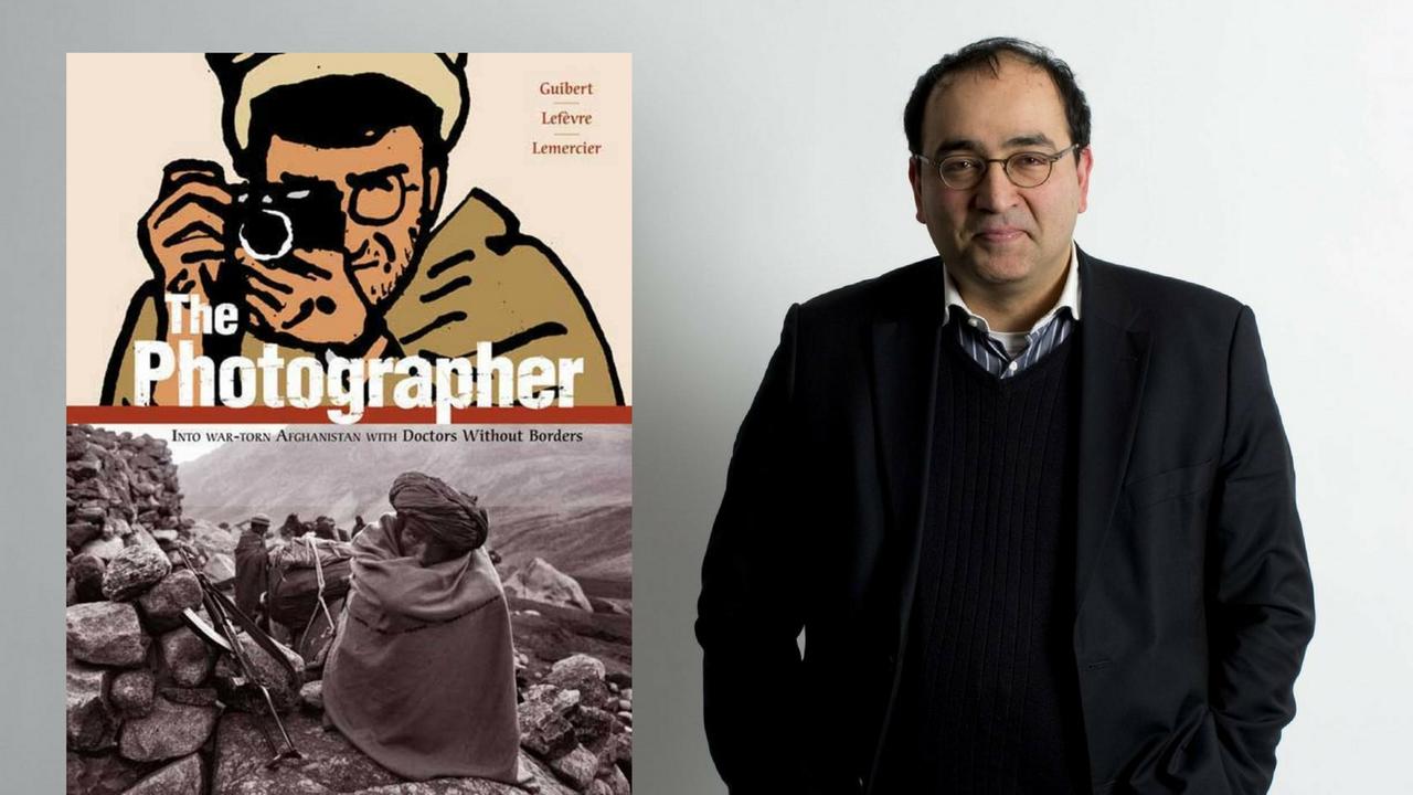 Omid Nouripour (MdB, Bündnis 90/Die Grünen) steht vor einer grauen Wand. Daneben das Cover des Buches "The Photographer".