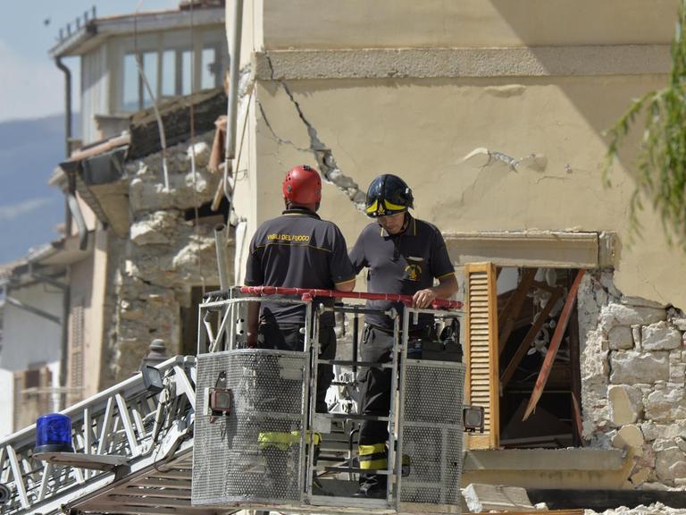 Feuerwehrleute untersuchen ein beschädigtes Gebäude in Amatrice - zwei Tage, nachdem ein Erdbeben dort schwere Zerstörungen verursacht hat. 267 Menschen wurden getötet.