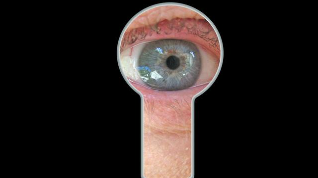 Ein Auge blickt durch eine Schlüsselloch. 