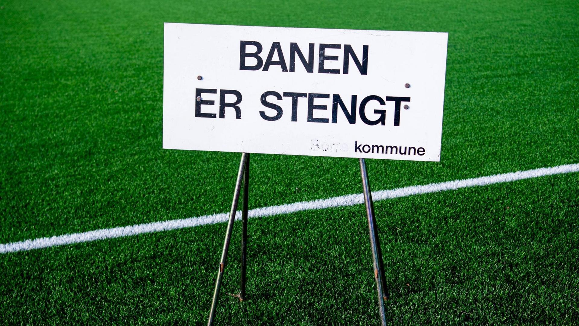 Ein Schild, das auf die Schließung hinweist, steht im März auf einem Fußballfeld im norwegischen Horten. Ein Schild, das auf die Schließung hinweist, steht im März auf einem Fußballfeld im norwegischen Horten.