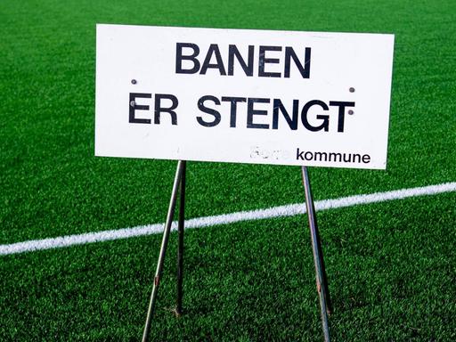 Ein Schild, das auf die Schließung hinweist, steht im März auf einem Fußballfeld im norwegischen Horten.