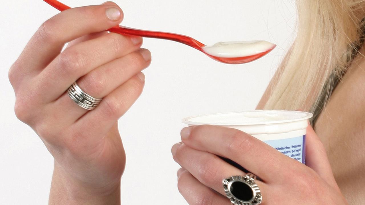 Eine Frau isst einen Joghurt Eine Frau isst einen Joghurt