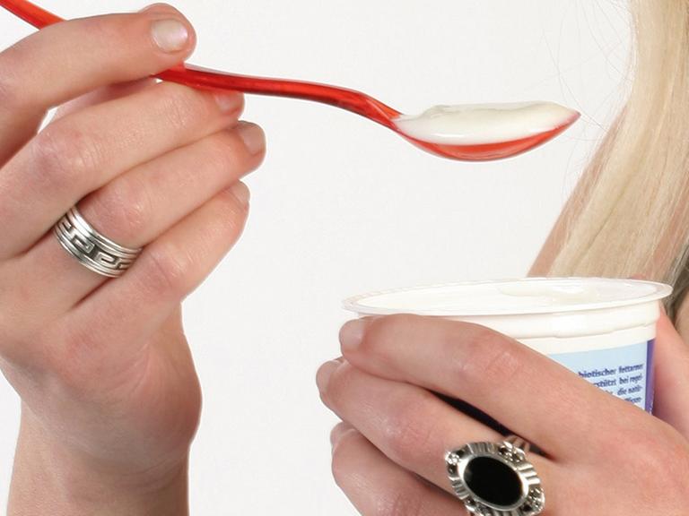 Eine Frau isst einen Joghurt