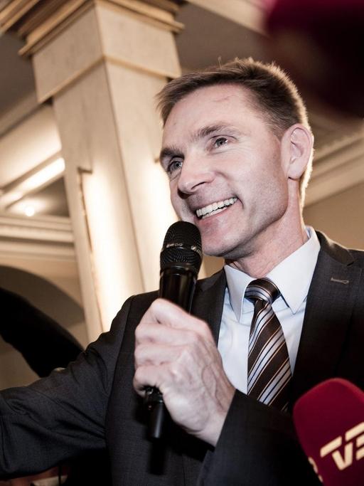 Zu sehen ist der Vorsitzende der rechtspopulistischen Volkspartei, Thulesen Dahl. Er winkt lachend und hält ein Mikrofon in der Hand.