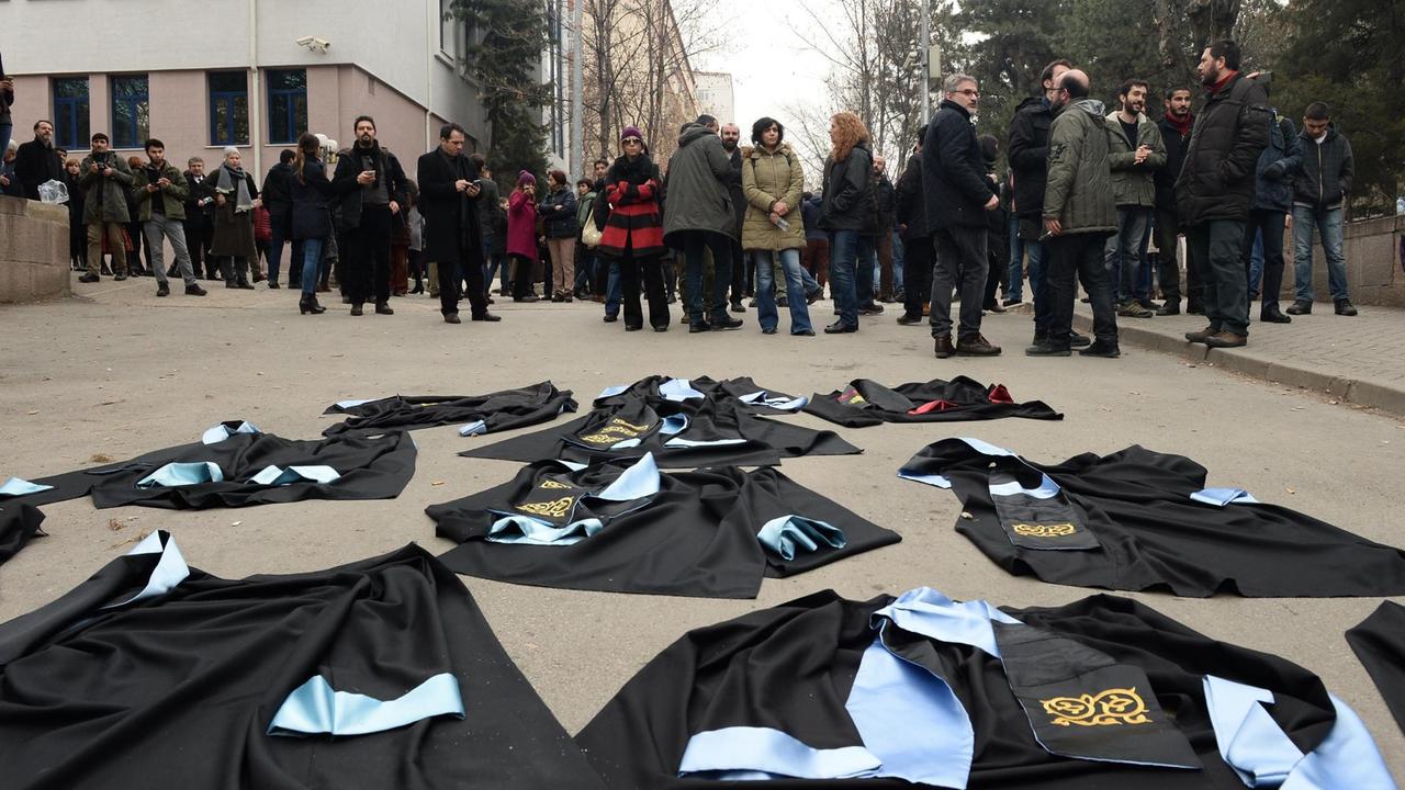 Wissenschaftler in Ankara haben aus Protest gegen die Entlassung von Kollegen ihre Talare vor die Universtät gelegt.