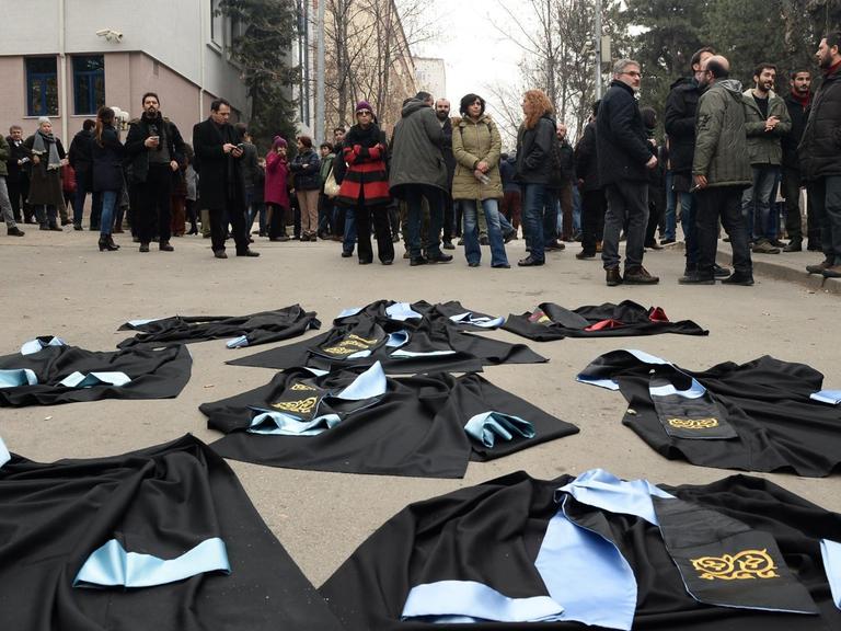 Wissenschaftler in Ankara haben aus Protest gegen die Entlassung von Kollegen ihre Talare vor die Universtät gelegt.