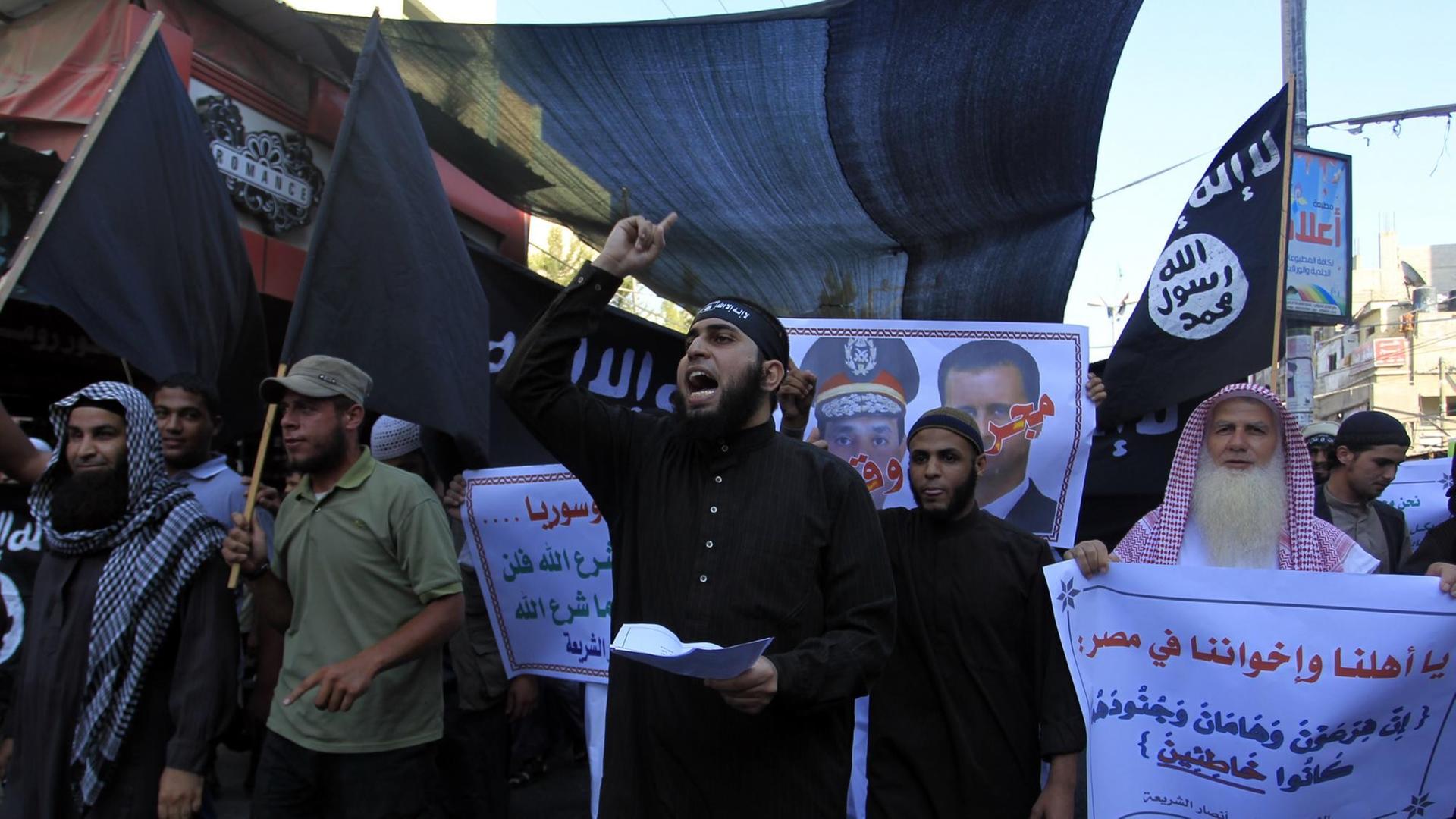 Palästinensische Salafisten auf einer Demonstration in Rafah 2013. Männer tragen Plakate und rufen Slogans auf einer Demo. Palästinensische Salafisten auf einer Demonstration in Rafah 2013. Männer tragen Plakate und rufen Slogans auf einer Demo.