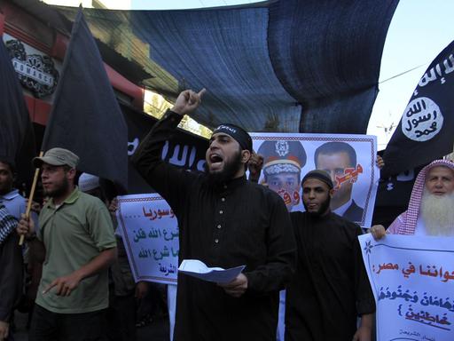 Palästinensische Salafisten auf einer Demonstration in Rafah 2013. Männer tragen Plakate und rufen Slogans auf einer Demo.