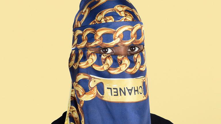 Eine Frau mit Chanel-Hidjab auf dem eine Kette zu sehen ist. Eine Frau mit Chanel-Hidjab auf dem eine Kette zu sehen ist.
