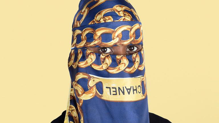 Eine Frau mit Chanel-Hidjab auf dem eine Kette zu sehen ist. Eine Frau mit Chanel-Hidjab auf dem eine Kette zu sehen ist.