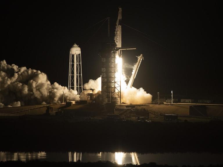 Die Rakete startet in der Dunkelheit. Qualm und Licht sind zu sehen.