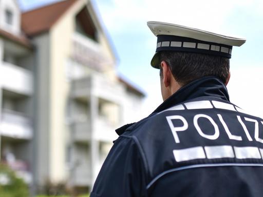 Der freiwillige Polizist Andreas Kaminski steht in Ludwigshafen (Rheinland-Pfalz) in Polizeiuniform vor einem Wohnhaus.