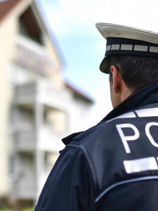 Der freiwillige Polizist Andreas Kaminski steht in Ludwigshafen (Rheinland-Pfalz) in Polizeiuniform vor einem Wohnhaus.
