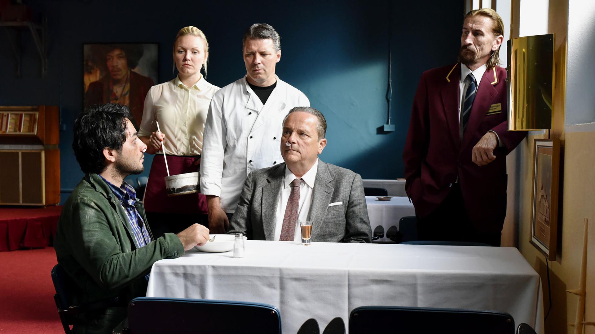 Szene aus "Die andere Seite der Hoffnung" von Aki Kaurismäki: Sherwan Haji (v.l.n.r., Khaled), Nuppu Koivu (Mirja), Janne Hyytiäinen (Nyrhinen), Sakari Kuosmanen (Wikström) und Ilkka Koivula (Calamnius) Szene aus "Die andere Seite der Hoffnung" von Aki Kaurismäki: Sherwan Haji (v.l.n.r., Khaled), Nuppu Koivu (Mirja), Janne Hyytiäinen (Nyrhinen), Sakari Kuosmanen (Wikström) und Ilkka Koivula (Calamnius)