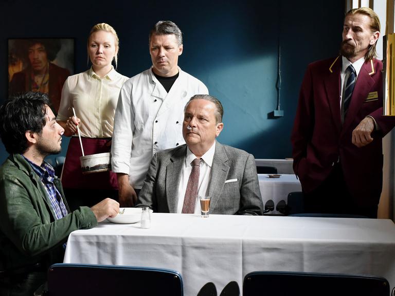 Szene aus "Die andere Seite der Hoffnung" von Aki Kaurismäki: Sherwan Haji (v.l.n.r., Khaled), Nuppu Koivu (Mirja), Janne Hyytiäinen (Nyrhinen), Sakari Kuosmanen (Wikström) und Ilkka Koivula (Calamnius)