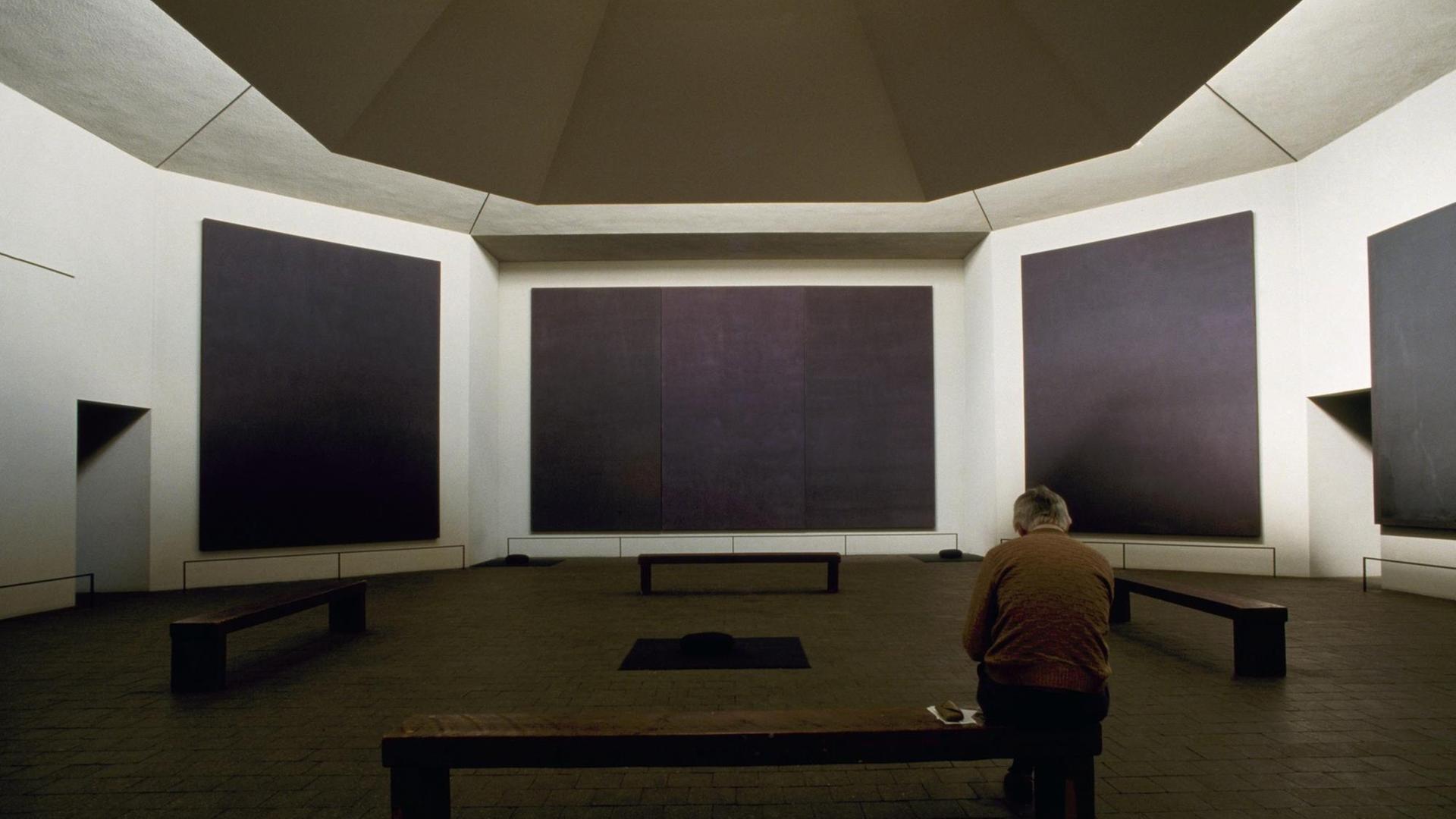 Ein Besucher sitzt auf einer Bank in der Mark Rothko Chapel in Houston Texas. Ein Besucher sitzt auf einer Bank in der Mark Rothko Chapel in Houston Texas.