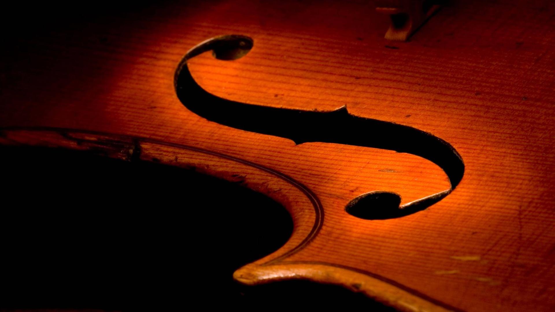 Das Schallloch einer Bratsche wird in einer Detailaufnahme vom Instrument durch einen Lichtkegel hervorgehoben. Das Schallloch einer Bratsche wird in einer Detailaufnahme vom Instrument durch einen Lichtkegel hervorgehoben.