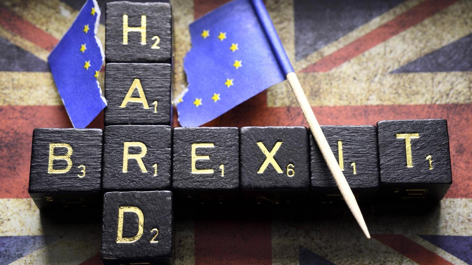 Buchstabenwürfel formen die Worte hard und brexit auf dem Union Jack