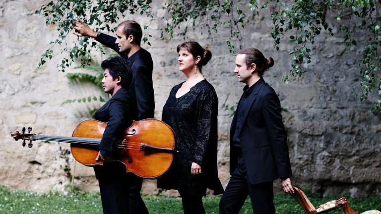 Das Quatuor Cambini-Paris im Grünen, mit Violoncello und antikem Stuhl Das Quatuor Cambini-Paris im Grünen, mit Violoncello und antikem Stuhl