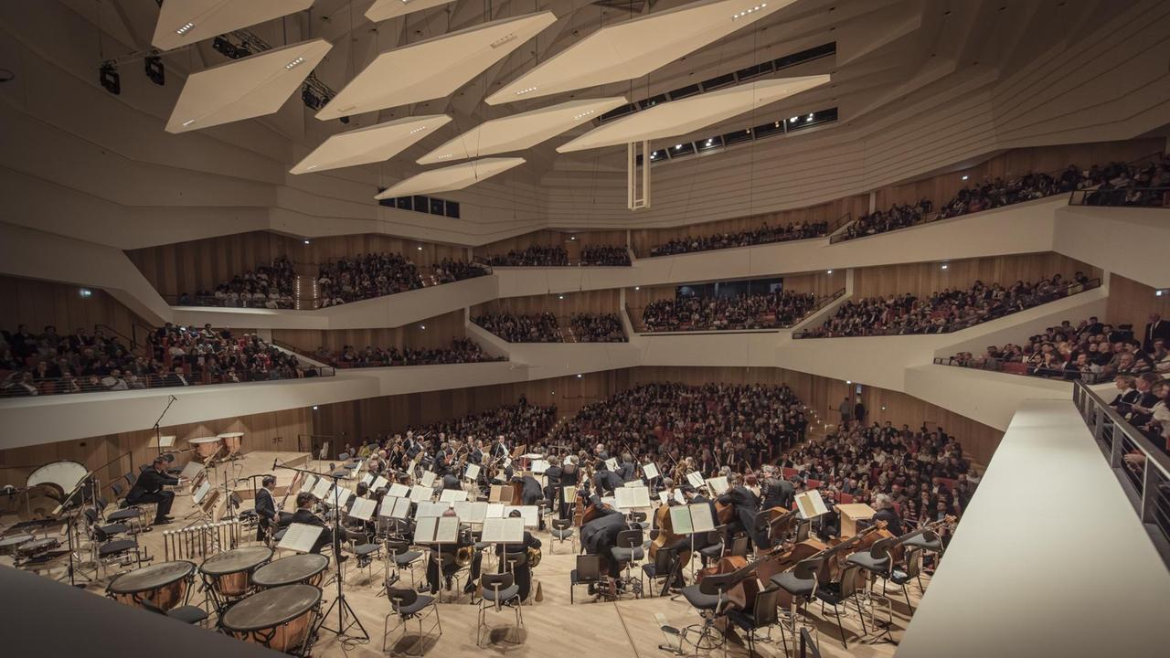 Im modernen Konzertsaal spielt das Orchester.