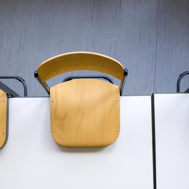Blick von oben auf einen Tisch mit hochgestellten Schulstühlen