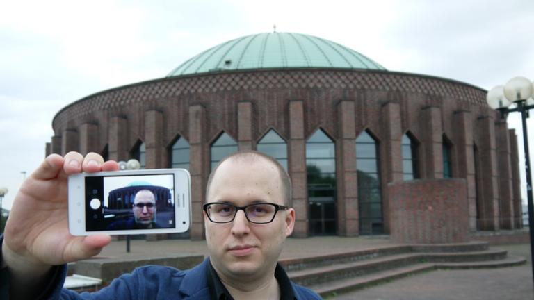 Martin Tchiba mach ein Selfie vor der Tonhalle Düsseldorf