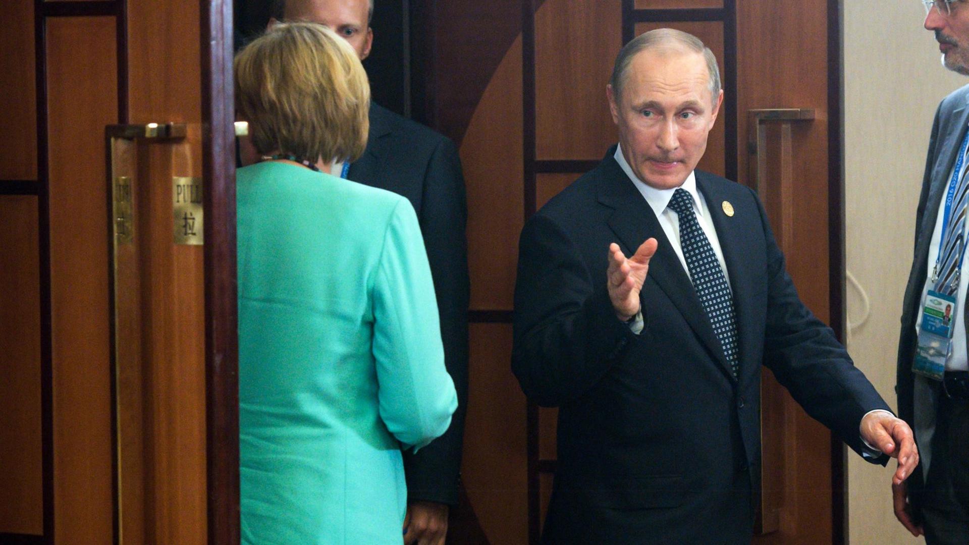 Bundeskanzlerin Angela Merkel (CDU) kommt am 05.09.2016 in Hangzhou (China) mit dem russischen Präsident Wladimir Putin in einen Besprechungsraum beim G20-Gipfel zusammen. Bundeskanzlerin Angela Merkel (CDU) kommt am 05.09.2016 in Hangzhou (China) mit dem russischen Präsident Wladimir Putin in einen Besprechungsraum beim G20-Gipfel zusammen.