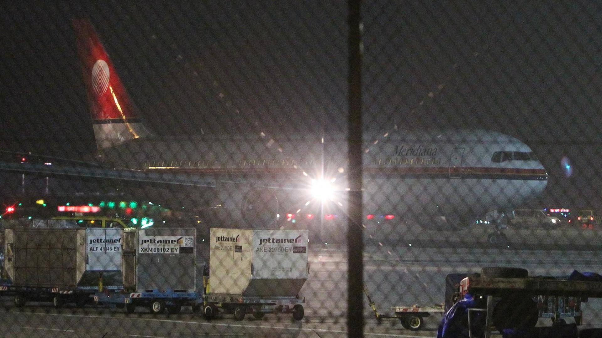 Das Flugzeug steht in der Dunkelheit hinter einem Zaun auf dem Frankfurter Flughafen. Das Flugzeug steht in der Dunkelheit hinter einem Zaun auf dem Frankfurter Flughafen.
