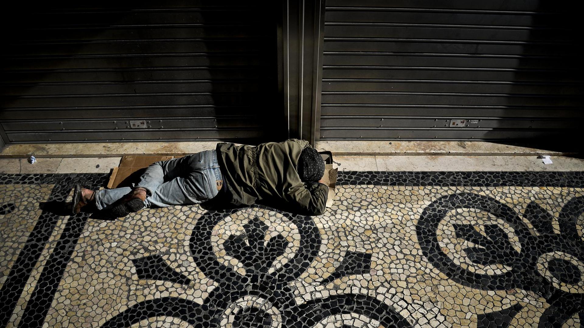 Ein Obdaloser schläft auf dem Boden, Lissabon, 03.07.2013