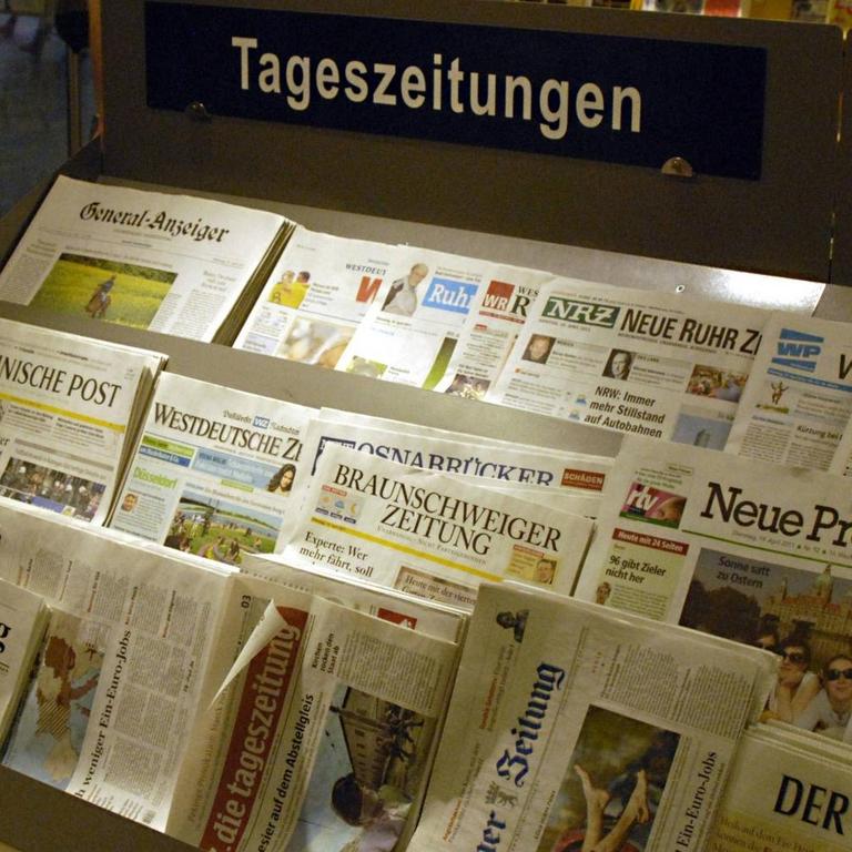 Auf einem Verkaufsstand liegen etliche verschiedene Tageszeitungen in der Auslage.