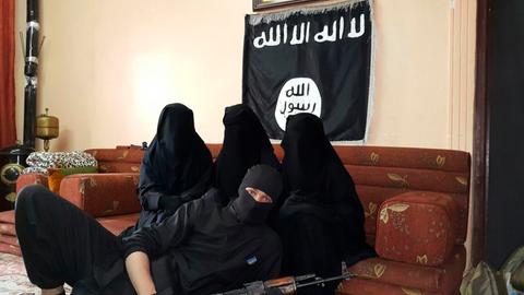 Drei vollverschleierte Frauen auf einer Couch und ein bewaffneter Mann liegt vor der Couch. Das offizielle Hochzeitsfoto von Leonora selbst als Drittfrau im "Islamischen Staat". Vater Maik Messing weiß bis heute nicht, welche der Frauen seine Tochter ist.