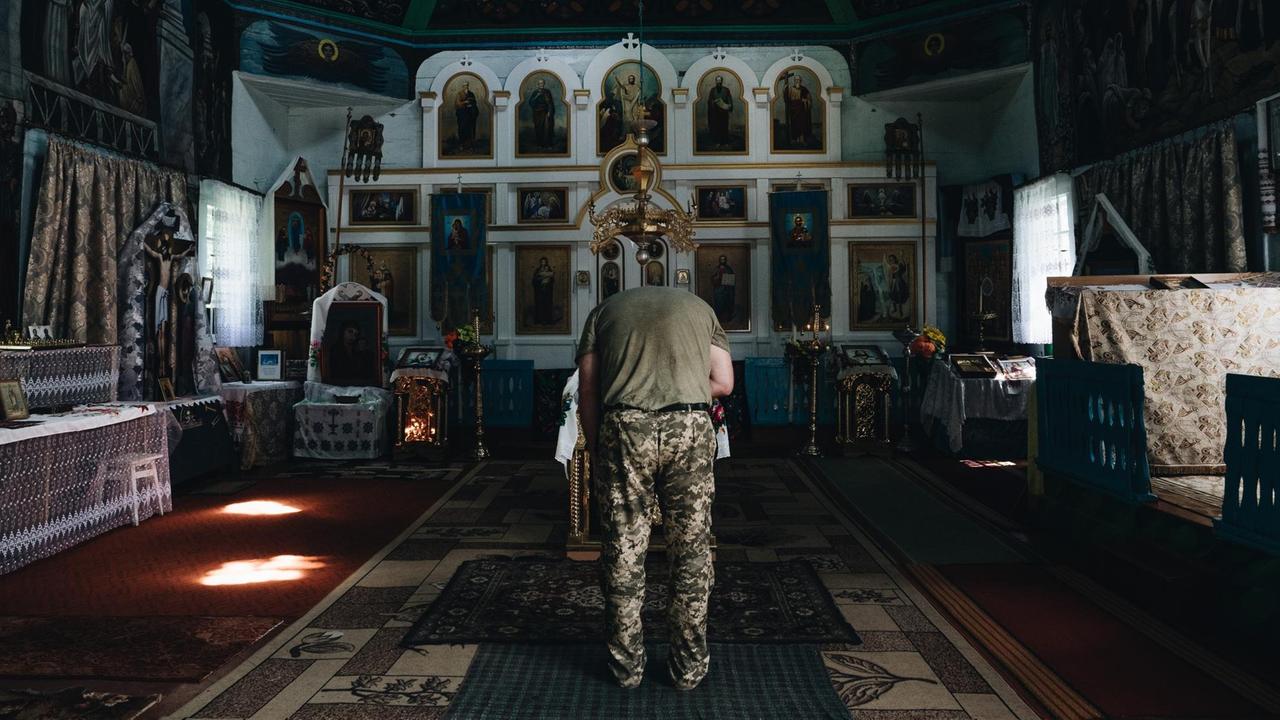 In einer reich geschmückten Kirche verbeugt sich Aleksej vor dem Altar.