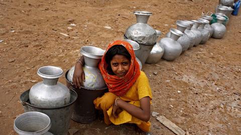Ein Mädchen in Bangladesch wartet auf Trinkwasser.