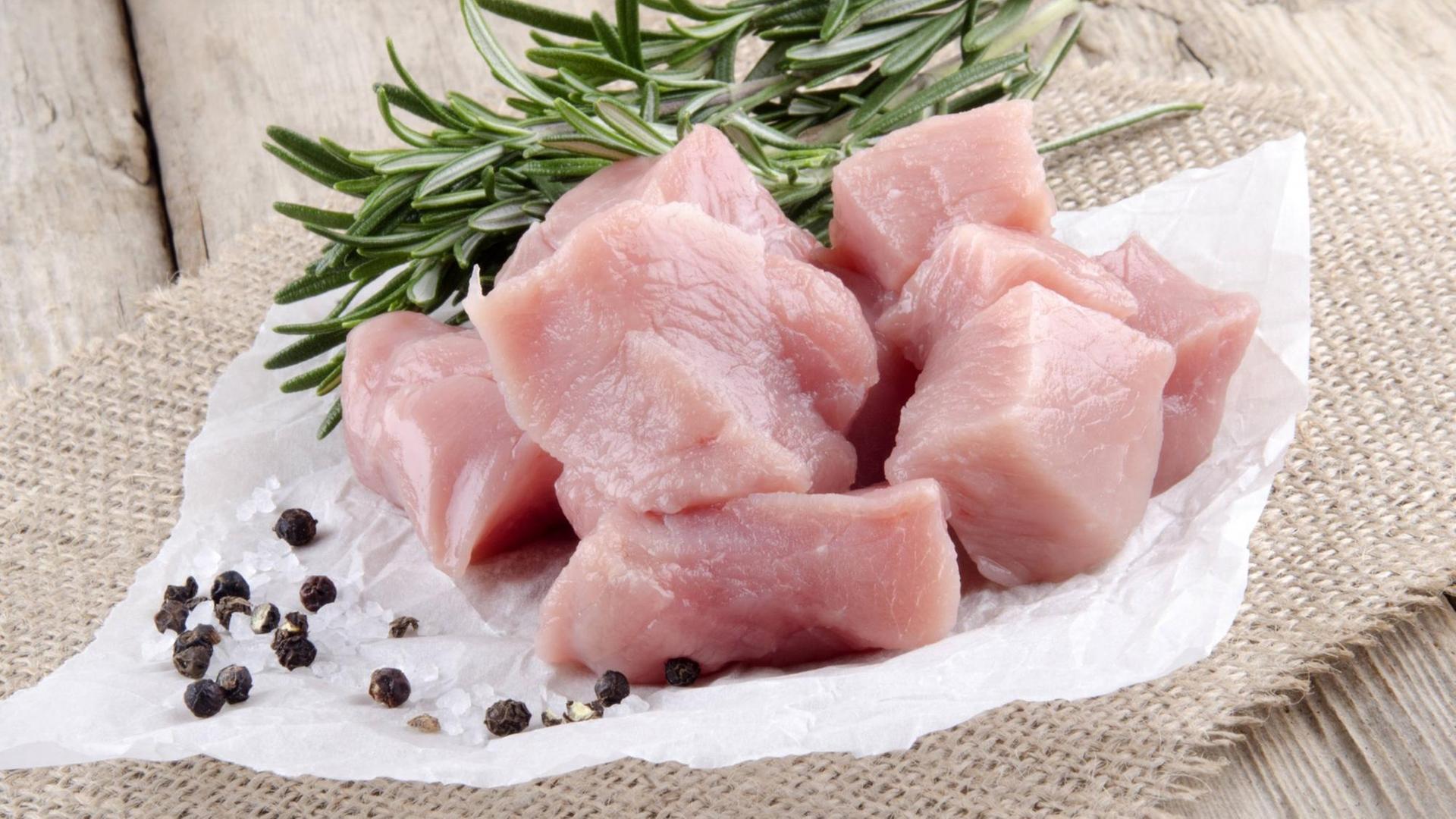 Schweinefleischstücke mit Pfeffer, Salz und Rosmarien drappiert. Schweinefleischstücke mit Pfeffer, Salz und Rosmarien drappiert.