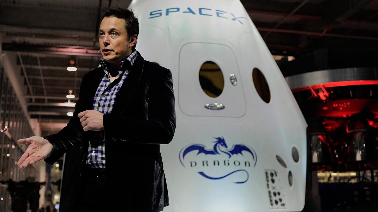 Elon Musk vor einem Modell des SpaceX