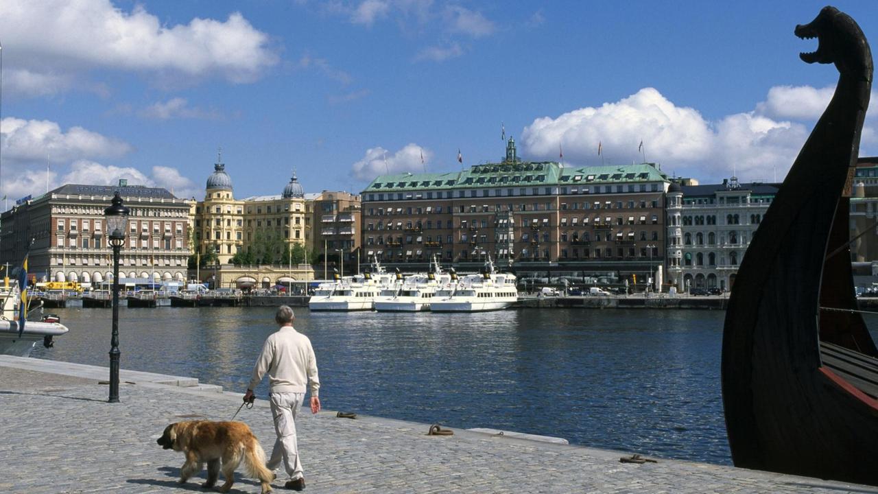Ein Spaziergänger an der Hafenpromenade Stravenvägen in Stockholm.