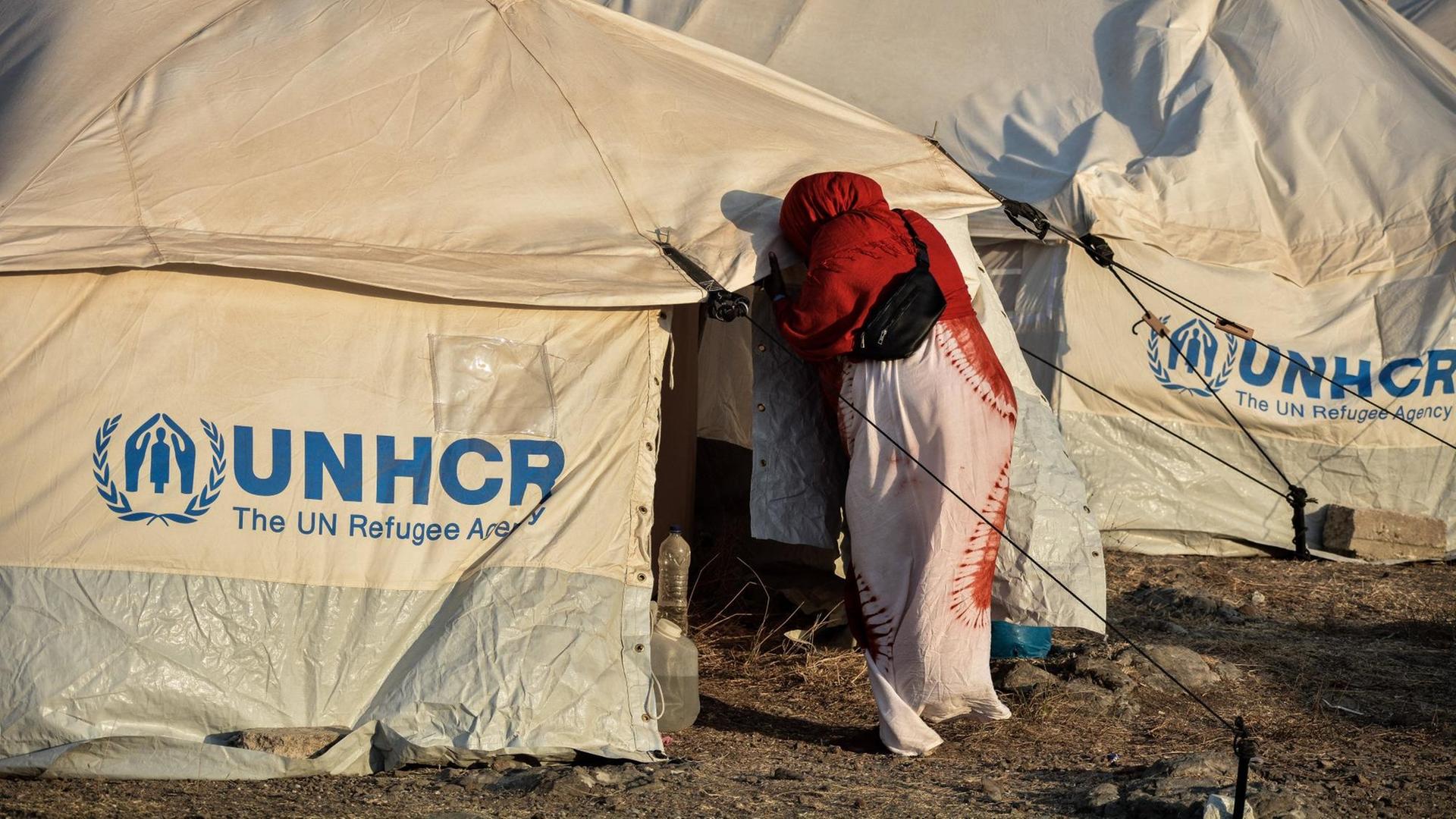 Momentaufnahme aus dem neuen Flüchtlingslager "Kara Tepe" auf der griechischen Insel Lesbos am 19. September 2020. Eine Frau betritt ein provisorisches Zelt der Hilfsorganisation UNHCR. Momentaufnahme aus dem neuen Flüchtlingslager "Kara Tepe" auf der griechischen Insel Lesbos am 19. September 2020. Eine Frau betritt ein provisorisches Zelt der Hilfsorganisation UNHCR.