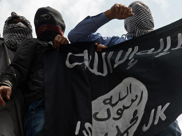 Unterstützer der Extremistenmiliz Islamischer Staat (IS) mit Fahne.