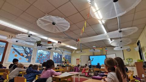 In einem Klassenzimmer ist über jedem Tisch eine selbst gebaute Abzugshaube montiert.