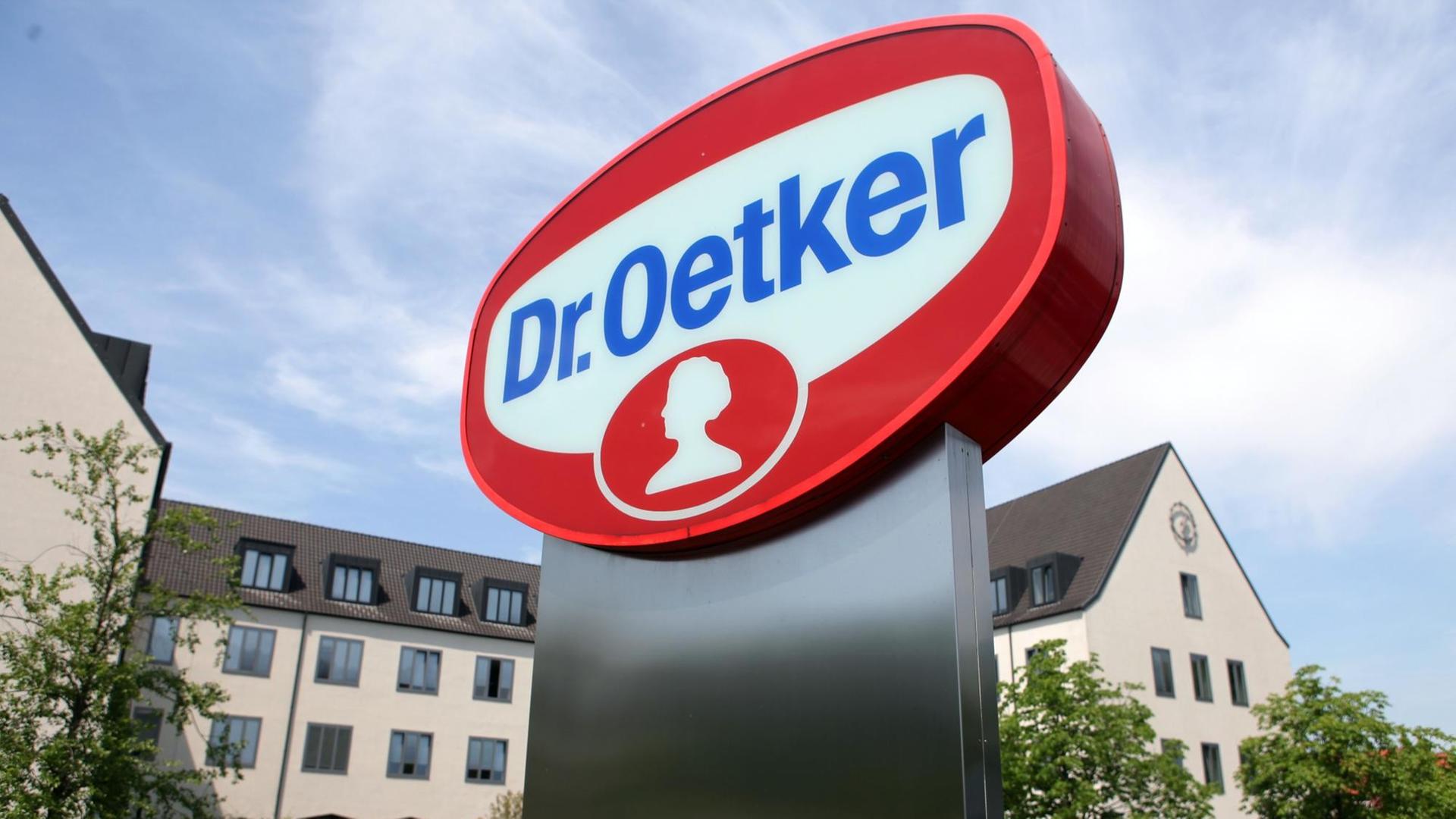 Foto vom Sitz der Dr. August Oetker KG in Bielefeld. Im Vordergrund ist das große Oetker-Logo in den Farben rot, blau und weiß zu sehen. Foto vom Sitz der Dr. August Oetker KG in Bielefeld. Im Vordergrund ist das große Oetker-Logo in den Farben rot, blau und weiß zu sehen.