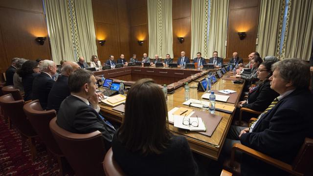 Teilnehmer der Friedensverhandlungen für Syrien sitzen in Genf an einem Konferenztisch.