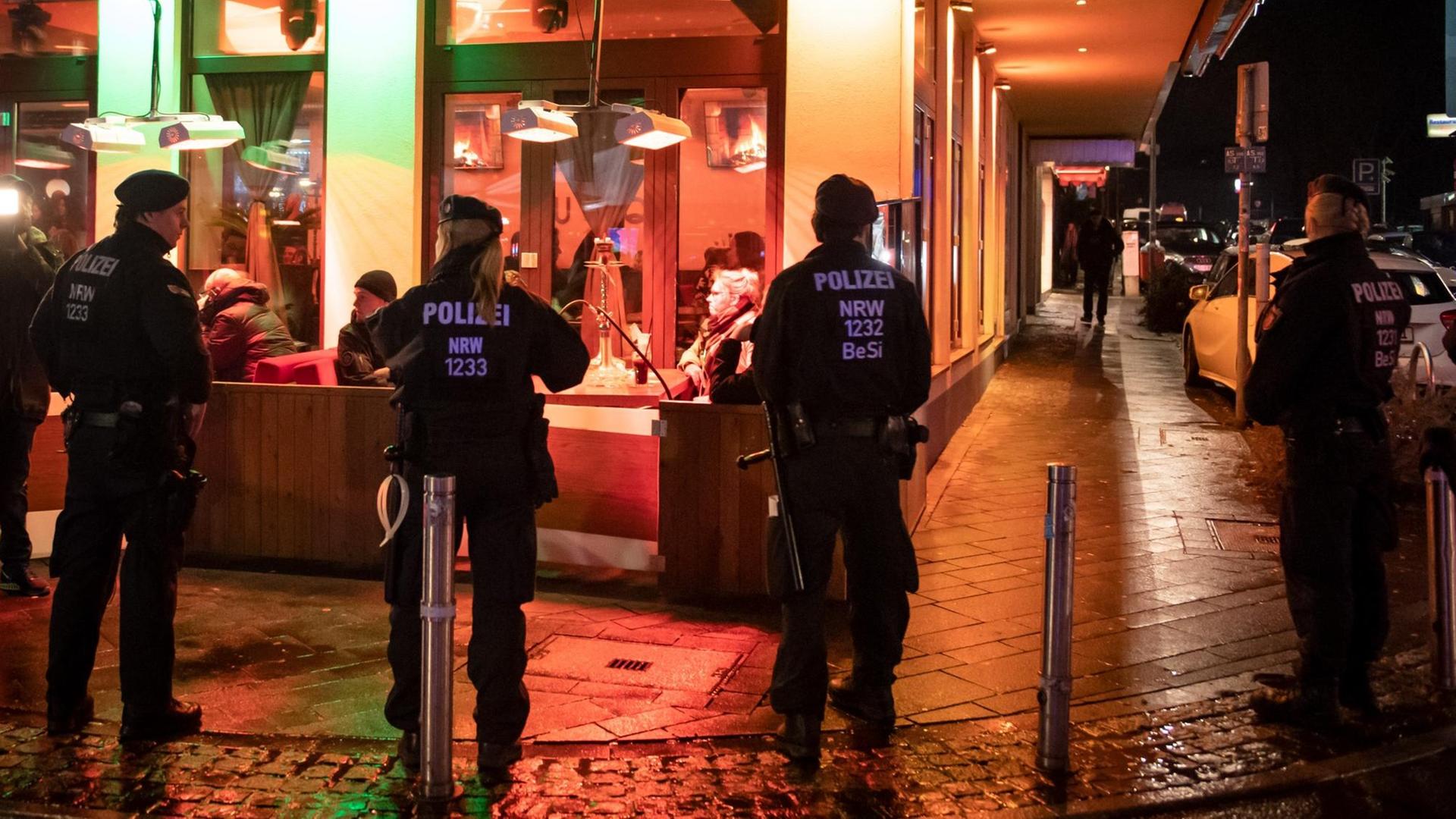Das Bild zeigt Polizisten, die ein Lokal bei Nacht von außen umstellt haben. Das Bild zeigt Polizisten, die ein Lokal bei Nacht von außen umstellt haben.