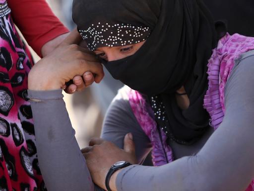 Eine jesidische Frau stützt in einem Flüchtlingscamp im Nordirak den Kopf auf die Hand
