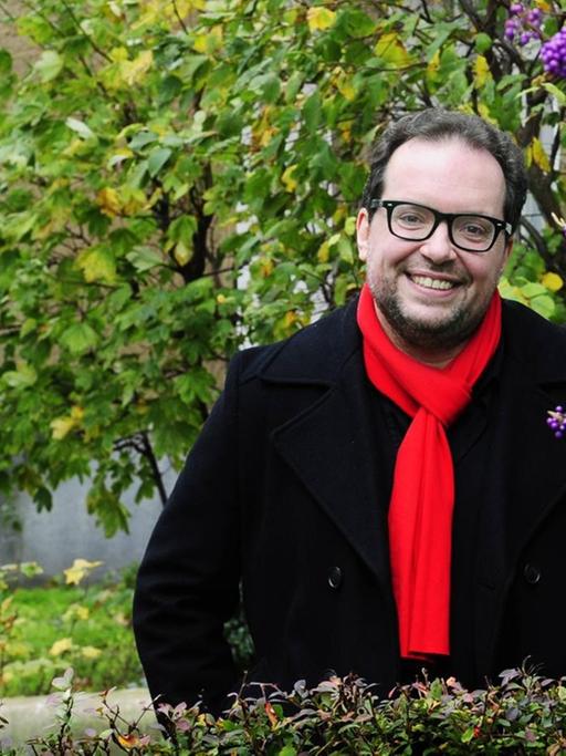 Dmitrij Belkin steht im Berliner Viertel Schöneberg zwischen Pflanzen.