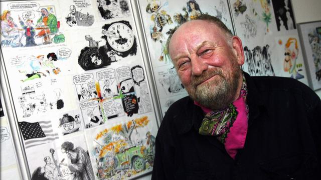 Der dänische Karikaturist Kurt Westergaard vor seinen Zeichnungen an seiner Wand.