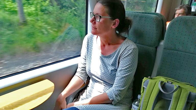Bloggerin Annalena Schmidt sitzt in einem Zug und schaut raus.