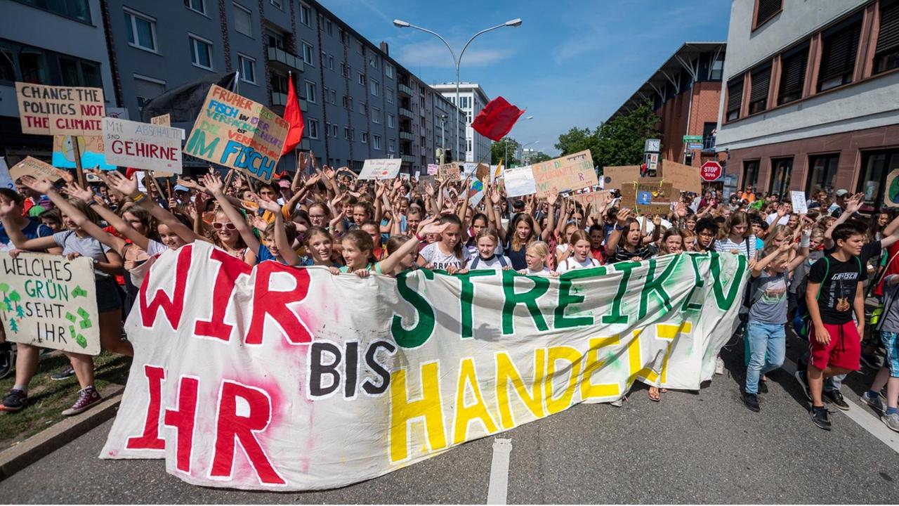 Baden-Württemberg, Freiburg: Teilnehmer halten während einer Fridays for Future Demonstration ein Banner mit der Aufschrift: «Wir streiken, bis ihr handelt». 