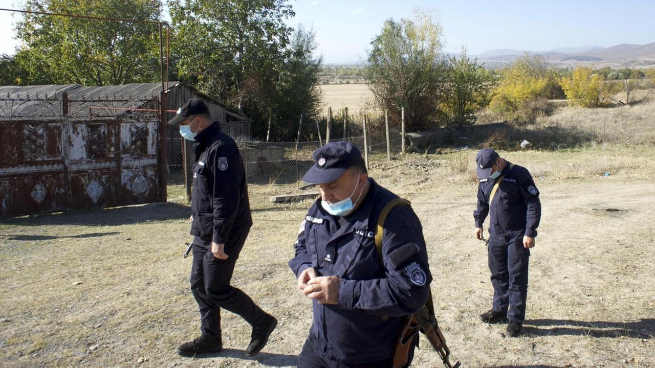 Drei georgische Polizisten in Churwaleti an der Grenze zu Südossetien. Sie gehen in Uniform durch das Dorf. Drei georgische Polizisten in Churwaleti an der Grenze zu Südossetien. Sie gehen in Uniform durch das Dorf.
