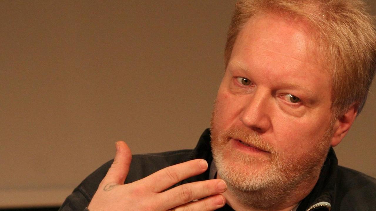 Jürgen Kuri, der stellvertretende Chefredakteur des c't Magazins, gestikulierend vor braunem Hintergrund Jürgen Kuri, der stellvertretende Chefredakteur des c't Magazins, gestikulierend vor braunem Hintergrund