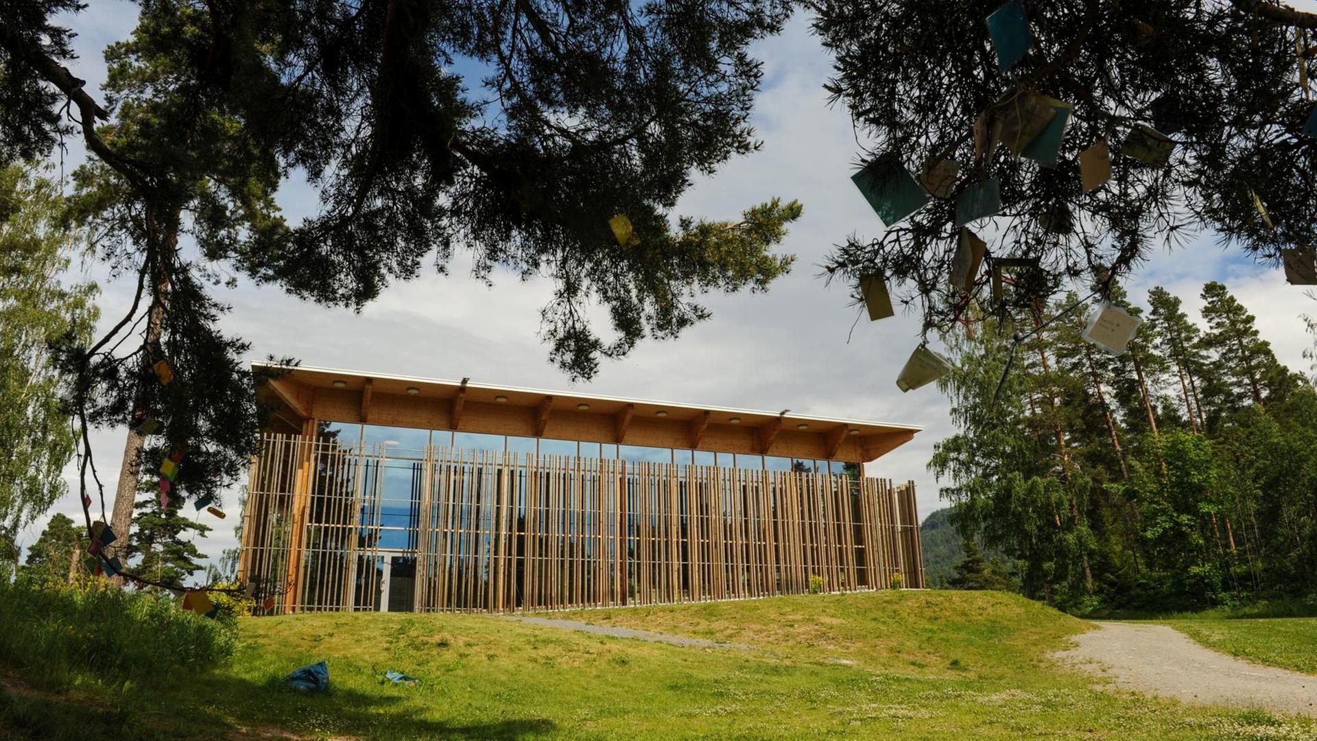 Auf einer Lichtung ist ein Haus mit Glasfront und Holzelementen zu sehen. Auf einer Lichtung ist ein Haus mit Glasfront und Holzelementen zu sehen.